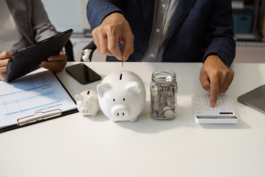 Homem guardando suas finanças na poupança em cofre com formato de porquinho